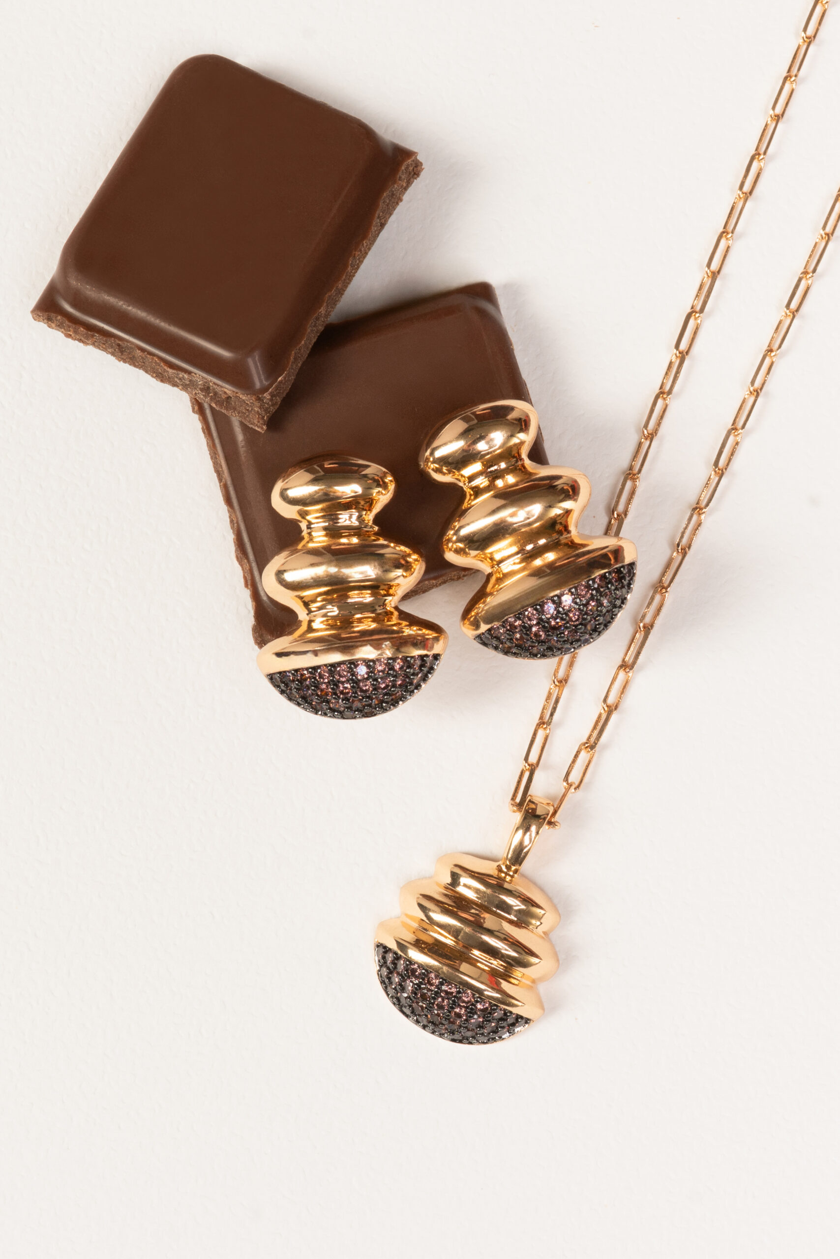 Conjunto dourado de pingente e brincos com cravejado escuro