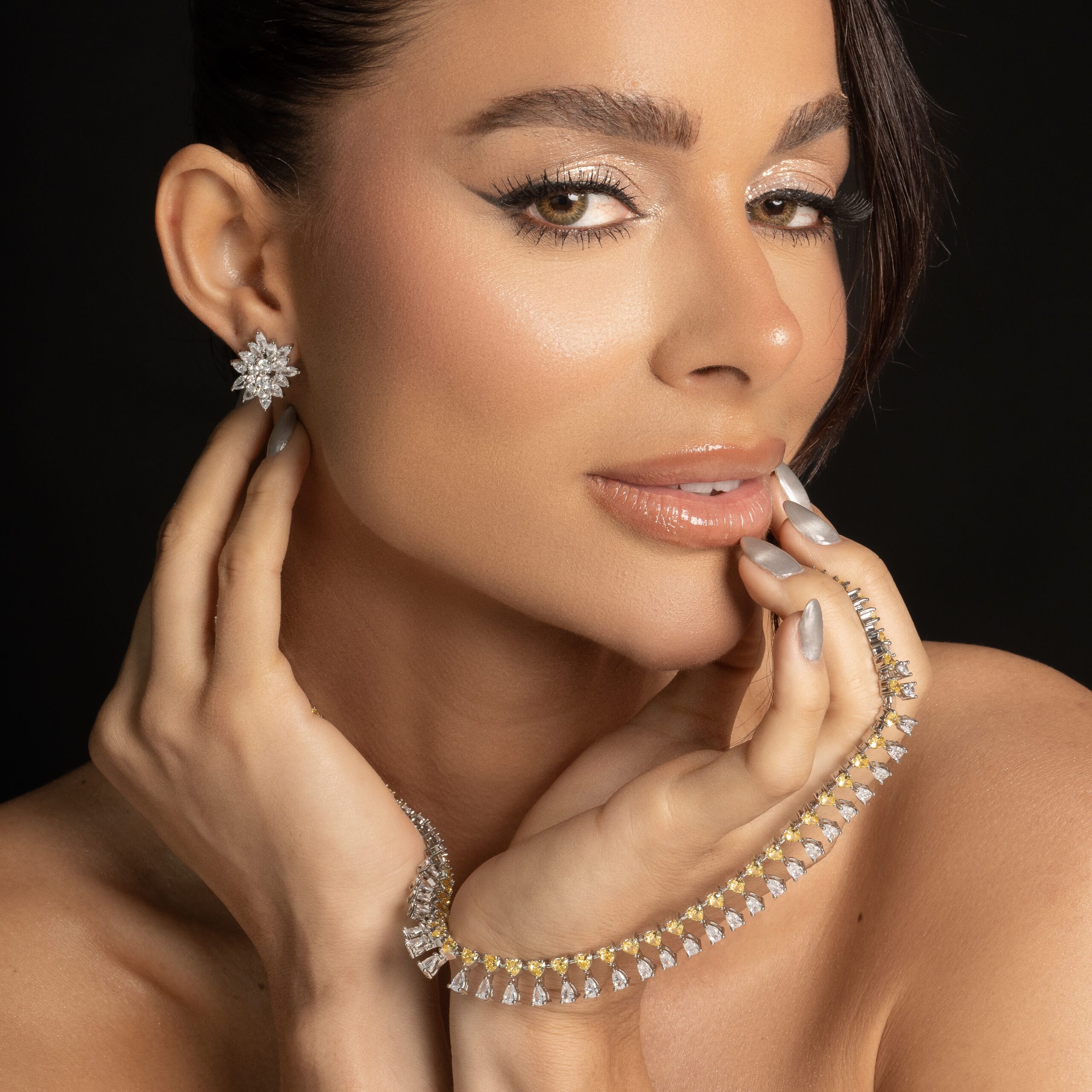 Modelo com brinco estrela e pulseira riviera dourada
